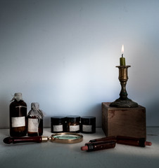 Obraz na płótnie Canvas old pharmacy. bottles, jars, candle on wooden shelves