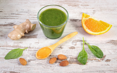 Ingredients and fresh cocktail from spinach on wooden background, healthy nutrition