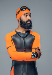 Bearded scuba diver male in orange neoprene suit isolated on gre