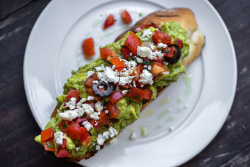 Bruschetta with tomato, avocado and herbs. Sandwich with avocado and tomatoes