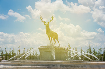 Deer statue in park with sunlight