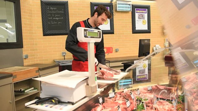 Butcher serving meat in supermarket