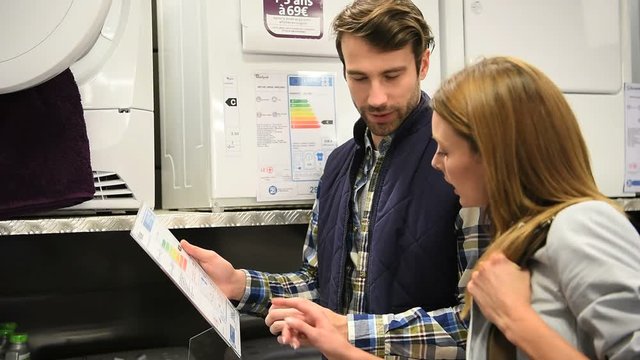 Seller helping customer with choosing dishwasher