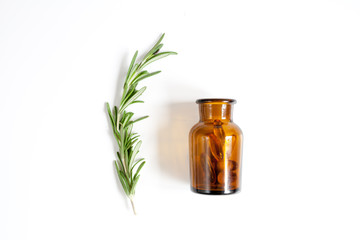 fresh rosemary with bottle on white background top view