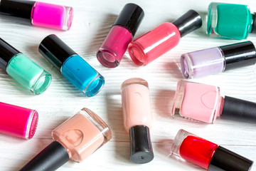 bottles of colored nail polish on wooden background