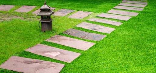 Gardening stone footpath with grass in the garden