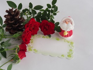 Blank christmas message card and Pale-colored Santa Claus on blurred red roses background
