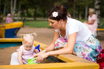 Small cute baby and nice mom outdoors