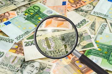 Czech and euro money background with magnifying glass