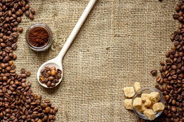 beans, ground coffee and sugar cane on linen cloth