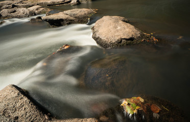 small river flowing through rocks and boulders during the fall in South Carolina