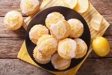  Sweet lemon muffins with zest and icing sugar close-up on a plate. horizontal top view © FomaA