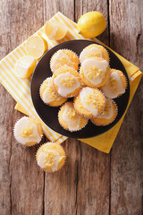 Homemade lemon muffins sprinkled with zest close-up on a plate. Vertical top view