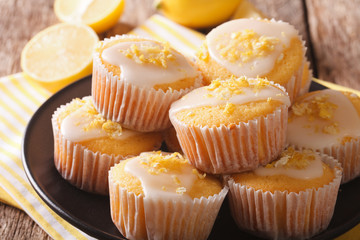 Homemade lemon muffins sprinkled with zest close-up on a plate. Horizontal