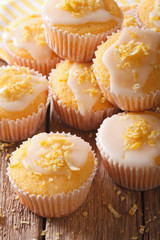 Glazed lemon muffins sprinkled with zest close-up. vertical