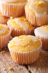 Delicious lemon muffins with icing and zest macro. vertical