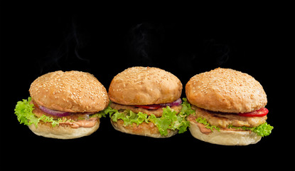 Three hamburgers on a dark background