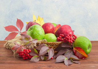 Fototapeta na wymiar Red and green apples on sackcloth in wicker basket