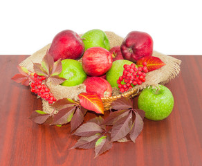 Red and green apples on sackcloth in wicker basket