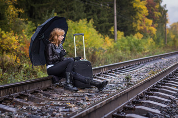 Girl, umbrella and rails in autumn day