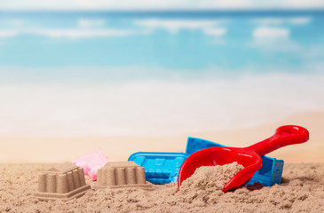 Bright children's toys in the sand against sea.