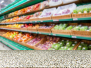 Marble empty table in front of blurred supermarket fruits shelf