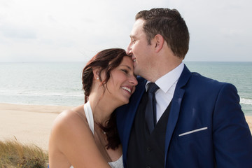 Just married couple on beach, hold their hands and kiss