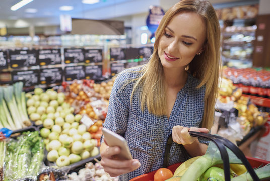 Woman using cellphone in grocery store
