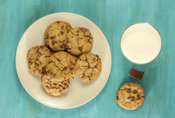 Chocolate chips cookies with glass of milk on blue texture