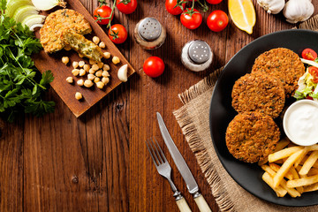 Serving of falafel and chips served on a black plate with sauce.