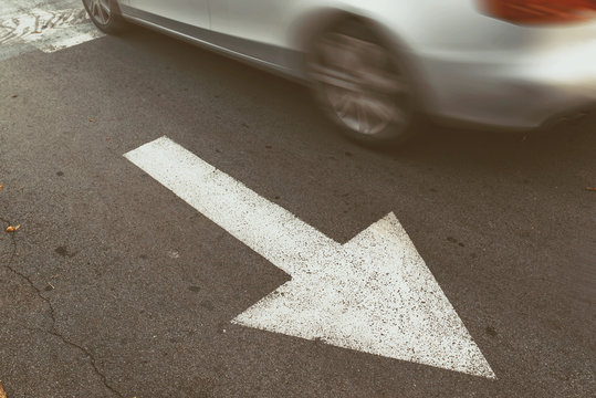 Driving car in wrong direction against traffic arrow sign