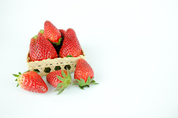 Fresh strawberries in a basket on white background.