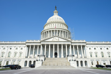 Front view of the Capitol Building in Washington DC, USA from in front of the entrance staircase under bright blue sky
