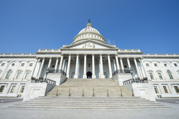 Fototapeta na wymiar Front view of the Capitol Building in Washington DC, USA from in front of the entrance staircase under bright blue sky
