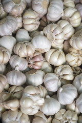Garlic bulbs stacked at an outdoor fruit and vegetable market