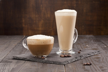 Cappuccino and Latte cups on the wooden table.