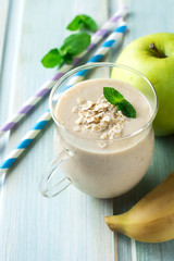Apple banana smoothies with oatmeal on a light background. Healthy breakfast. Selective focus.
