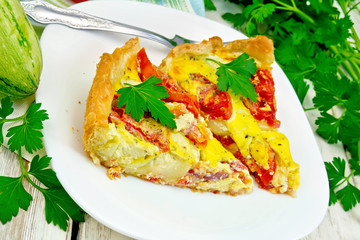 Flan with tomato and zucchini in plate on board