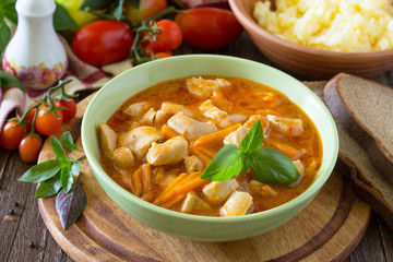 Traditional hot stew with meat on the aged wooden background. He