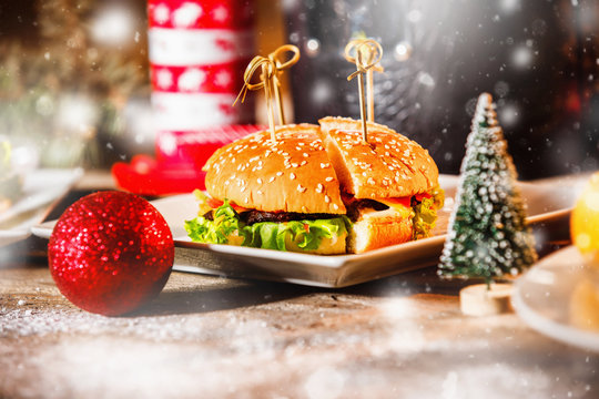 Hamburger on white plate at Christmas style decorated table