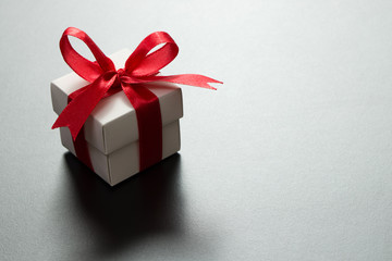 White gift box with red ribbon