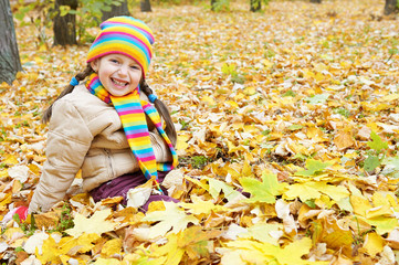 girl child sit in autumn forest, beautiful landscape in fall season with yellow leaves