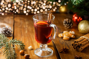 Glass of mulled wine by Christmas tree. Traditional delicious drink for New Year party