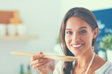 Cooking woman in kitchen with wooden spoon