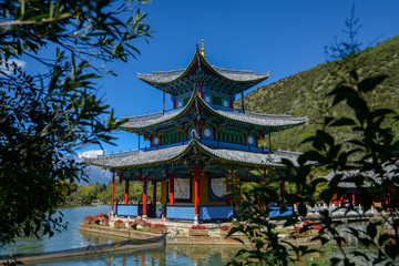 Black Dragon Pool to the Five Phoenix Tower. In the background is Jade Dragon Snow Mountain. The Old Town of Lijiang is located in Lijiang City, Yunnan, China.