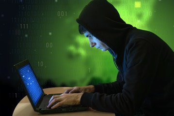 Hacker with laptop initiating cyber attack