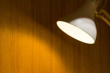 Desk lamp shining on a dark wall