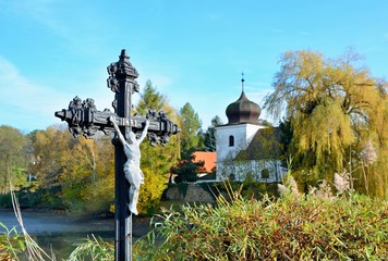 Jesus on cross outside in nature with church in background. INRI, Iesus Nazarenus Rex Iudaeorum