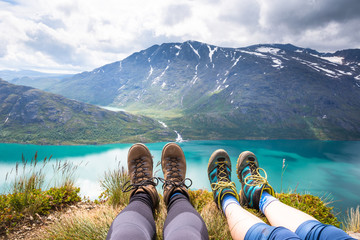 Sport couple hiking on Besseggen. Hikers enjoy beautiful lake and good weather in Norway.