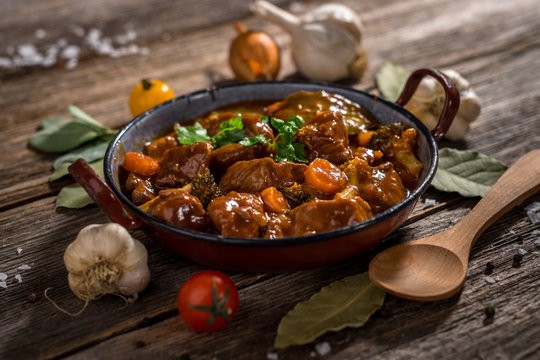 Meat stew with vegetable on rustic wooden background